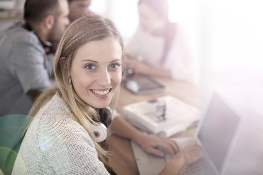 Student girl sitting in class and working on laptop